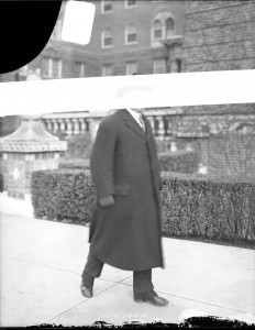Edward Hughes Glidden in front of the Homewood Apartments, face obscured