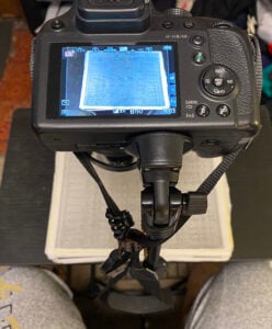 Photograph of a digital camera set up on a stand over a paper record