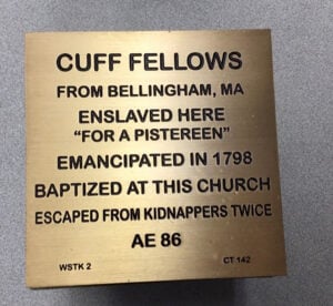 Witness stone for Cuff Fellows. "CUFF FELLOWS FROM BELLINGHAM, MA ENSLAVED HERE "FOR A PISTEREEN" EMANCIPATED IN 1798 BAPTIZED AT THIS CHURCH ESCAPED FROM KIDNAPPERS TWICE AE 86"